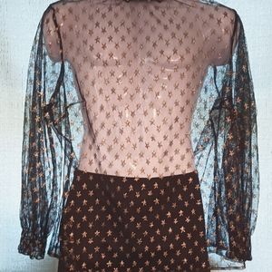Mesh like top with gold star shape sparkles and ruffley collar and wrists.